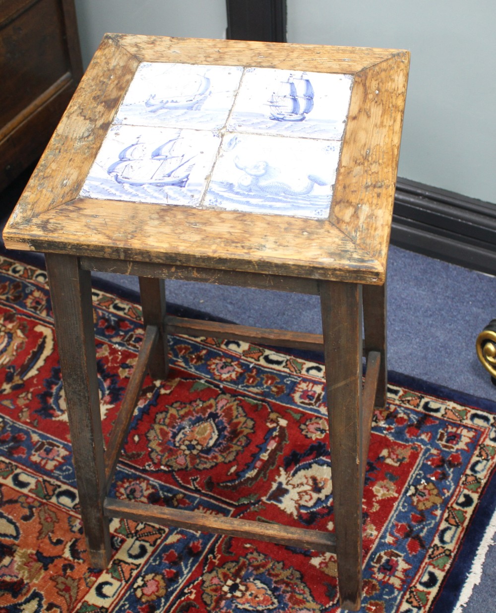 An early 20th century square pine occasional table, inset four Delft tiles, top 38cm sq., H.64cm